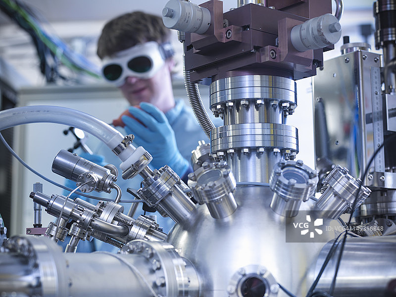 科学家在材料科学实验室中吹掉镜子上的灰尘图片素材