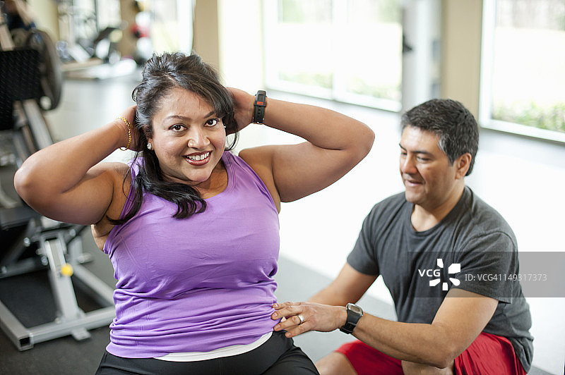 在健身房与教练一起锻炼的女人图片素材
