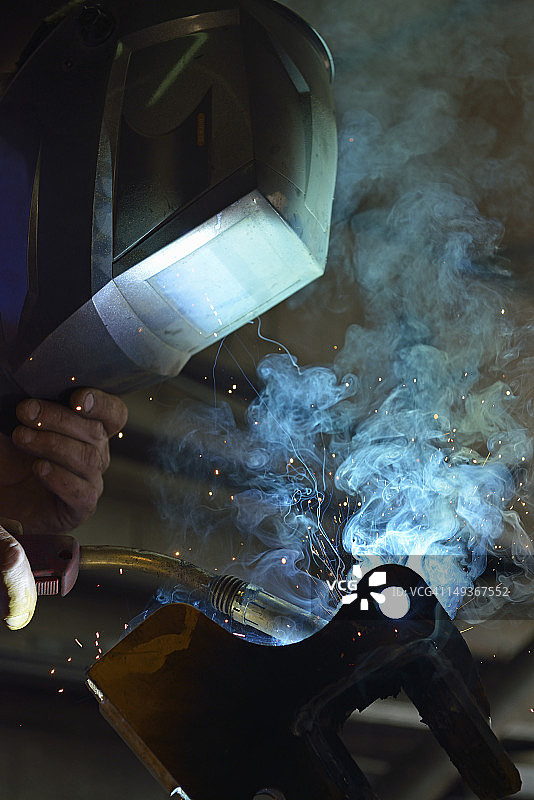 戴面罩的焊工焊接钢材图片素材