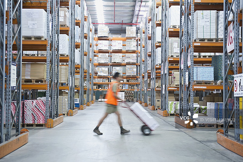 仓库中工人推着手推车图片素材