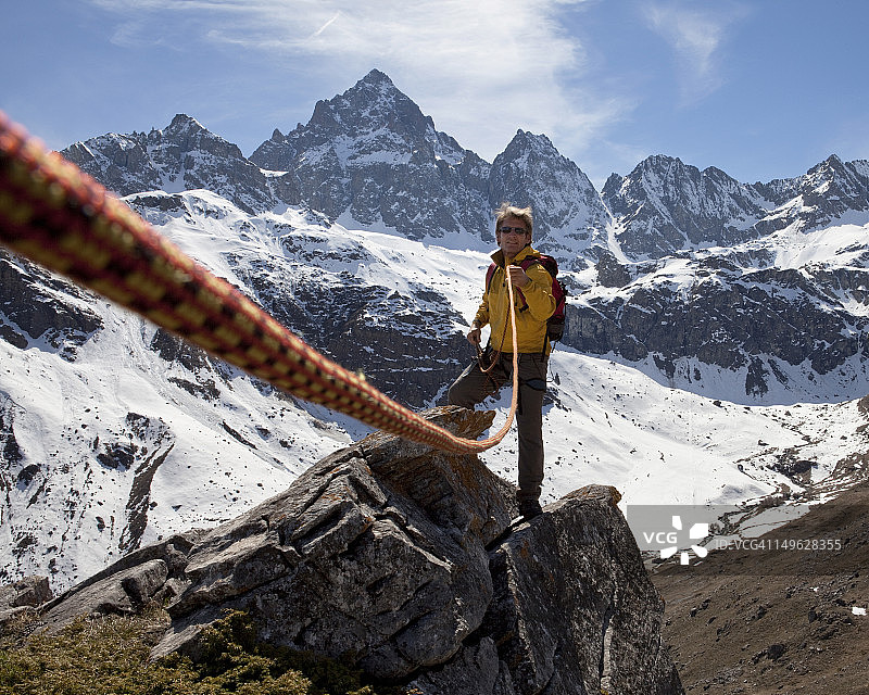 山间，男子拉绳帮助队友图片素材