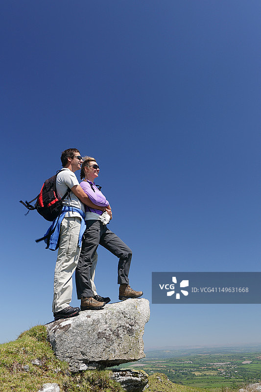 情侣在岩石上眺望风景图片素材