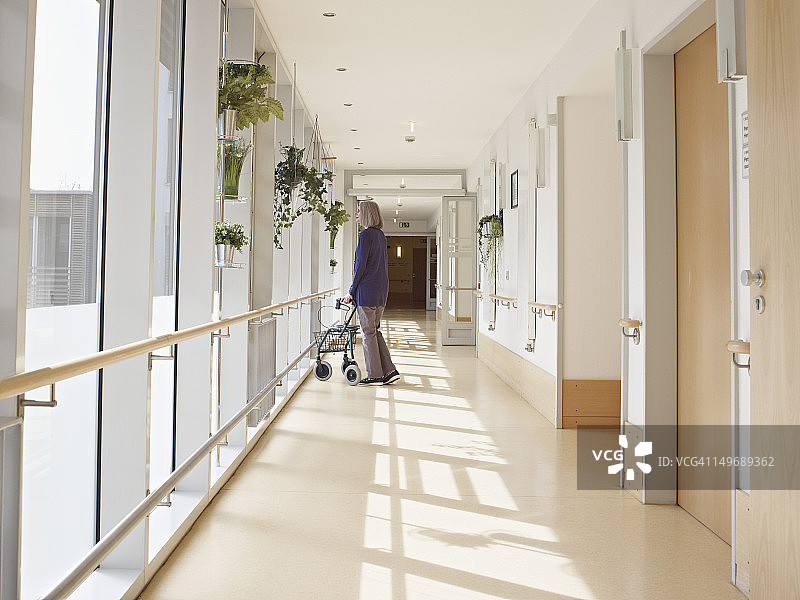 德国科隆：老妇人在疗养院走廊里扶着助行器图片素材