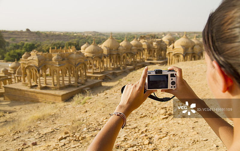 印度拉贾斯坦邦贾沙梅尔，女游客在巴达巴格陵墓群拍照图片素材