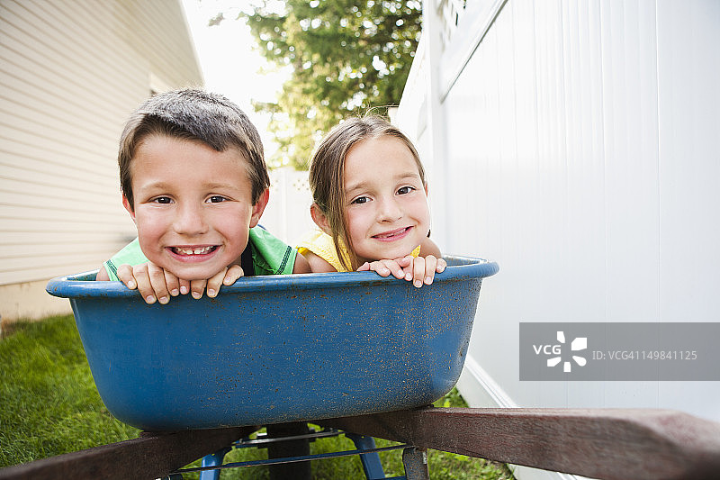 兄妹在独轮手推车里微笑图片素材