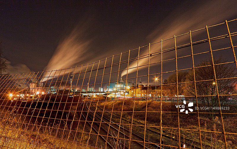 铁路轨道和围栏后的工业图片素材