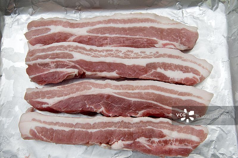 锡纸上的无皮生五花肉片图片素材