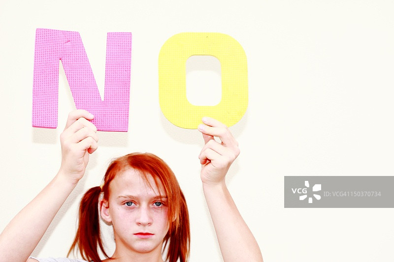 女孩拿着“NO”字母图片素材