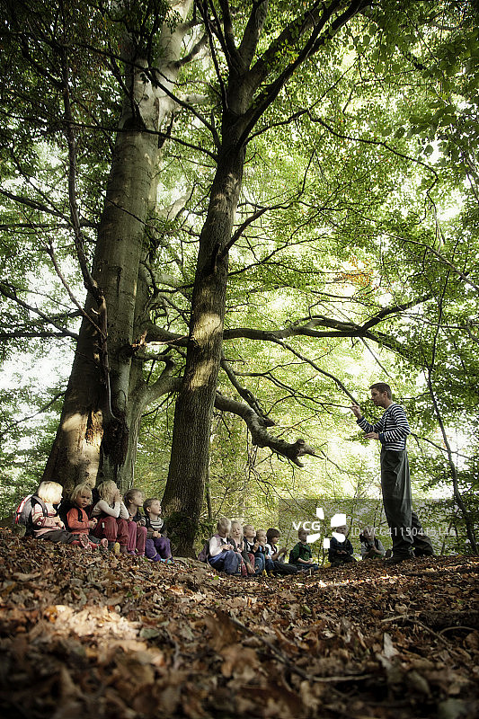 成年人在森林里给孩子们讲故事图片素材