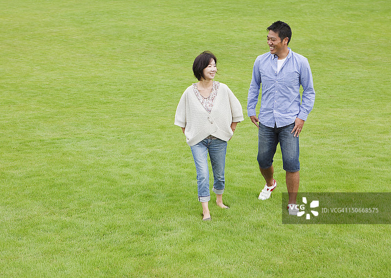情侣在草地上散步图片素材