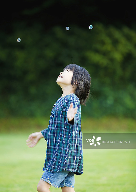 女孩抬头看肥皂泡图片素材