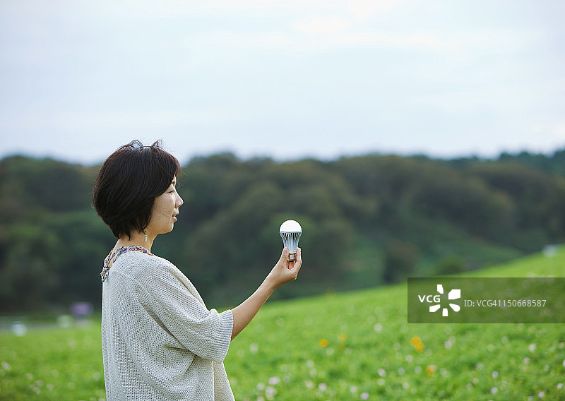 女人拿着LED灯泡图片素材