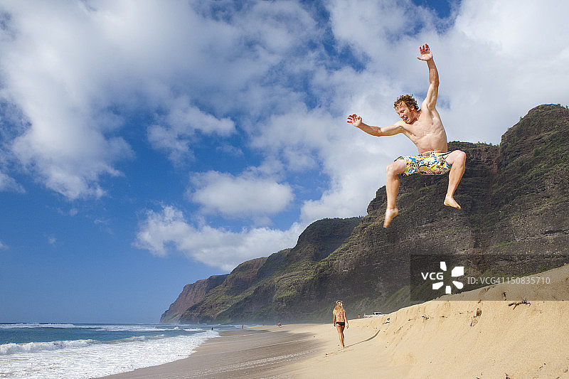 男孩在海滩上跳跃图片素材