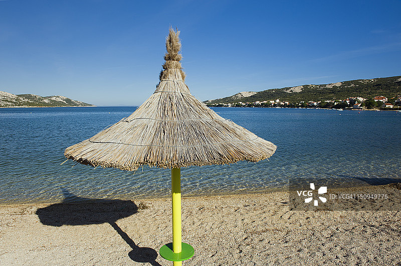 帕格岛亚得里亚海滩上的茅草遮阳伞图片素材