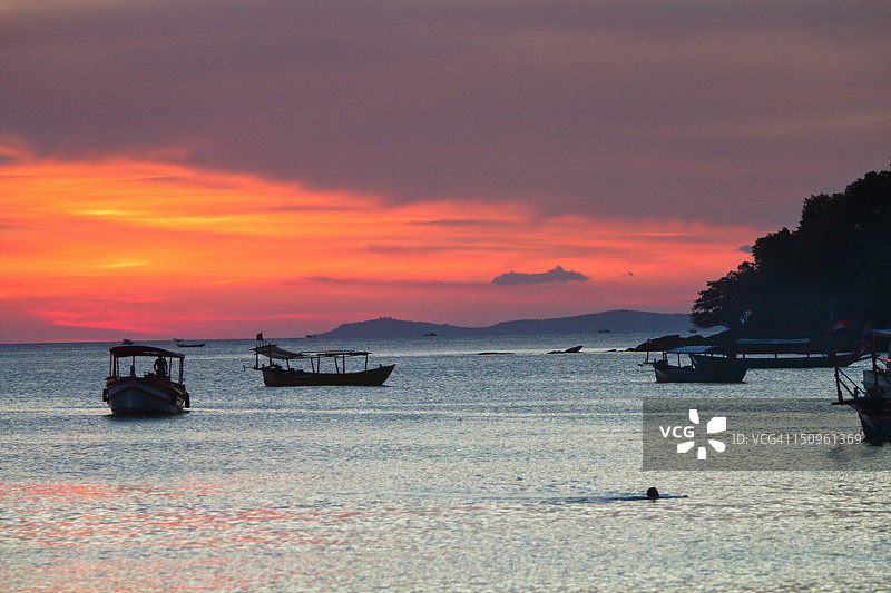 男子在日落时分畅游海洋图片素材