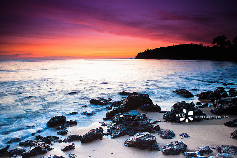 岛屿日落时的礁石水域图片素材