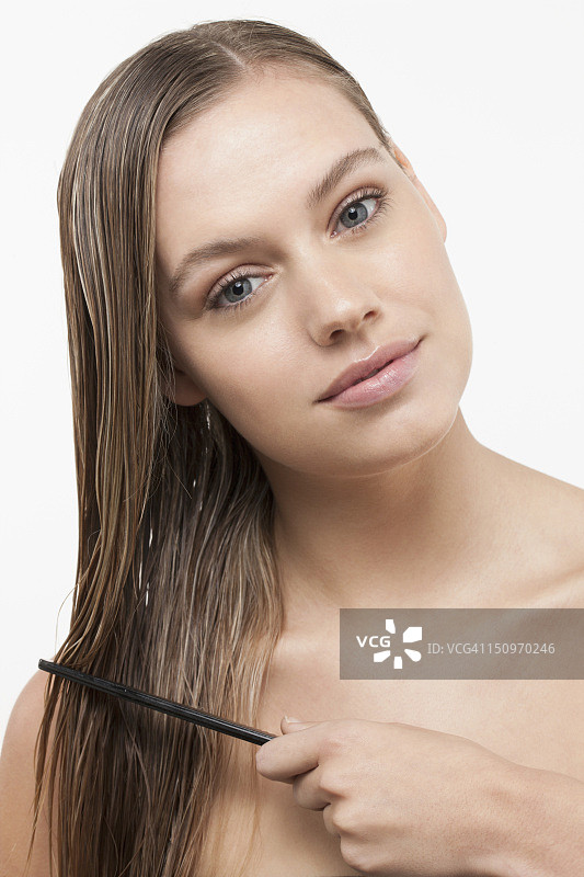 拿着梳子的湿发年轻女人肖像图片素材