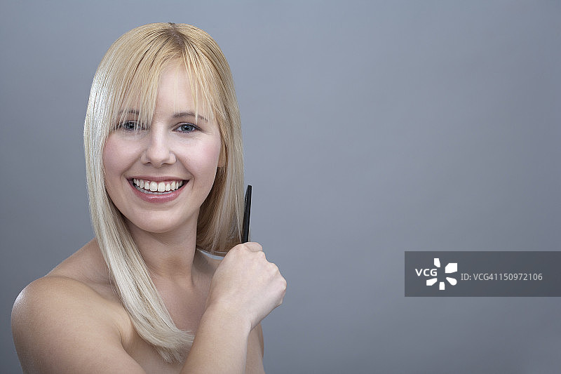 年轻女子梳头写真，影棚拍摄图片素材