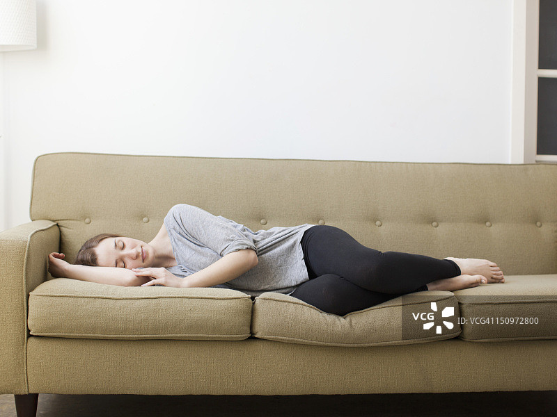 美国犹他州盐湖城，年轻女人在沙发上睡觉图片素材
