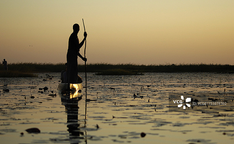 男人与奥卡万戈三角洲的莫科罗独木舟图片素材