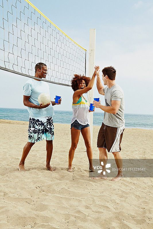 朋友们在沙滩上打排球图片素材