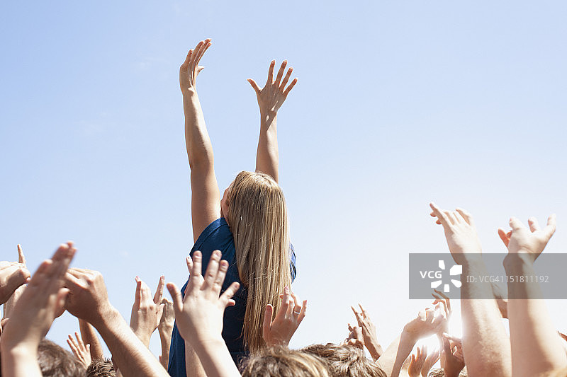 人群中举起双臂的女子图片素材