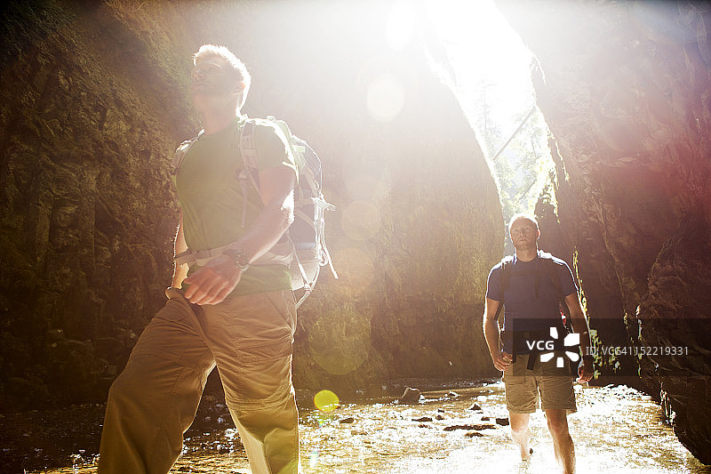 两个男人徒步穿越狭窄的峡谷图片素材