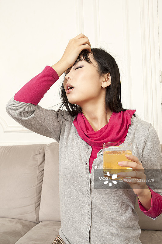 在沙发上喝果汁的女人图片素材