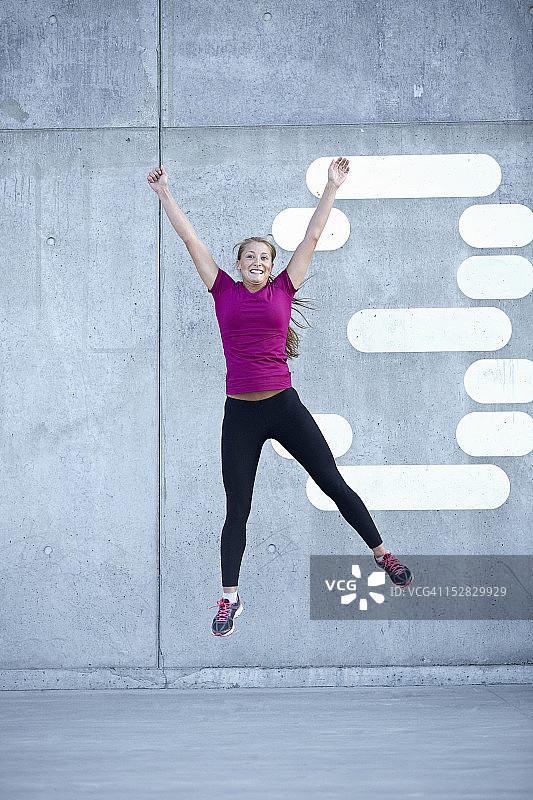 在城市街道上欢快跳跃的跑步者图片素材