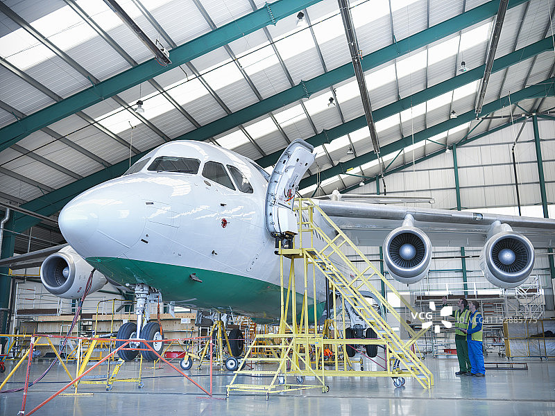 在机库检查喷气式飞机的工人们图片素材