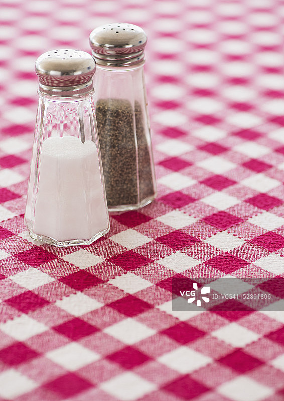 格子桌布上的盐和胡椒粉调味瓶图片素材