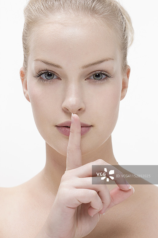 年轻女人用手指按住嘴唇图片素材