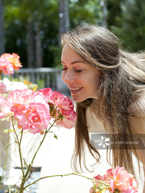 美国犹他州盐湖城：闻玫瑰花的年轻女子图片素材