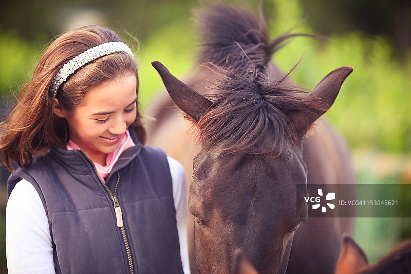 年轻女孩和纯种马拥抱图片素材