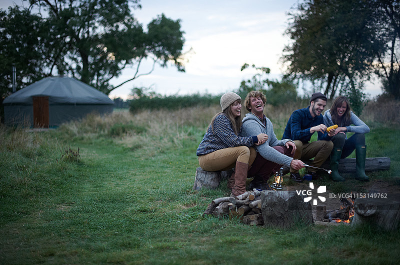 朋友们在豪华露营旅行中围坐在篝火旁图片素材