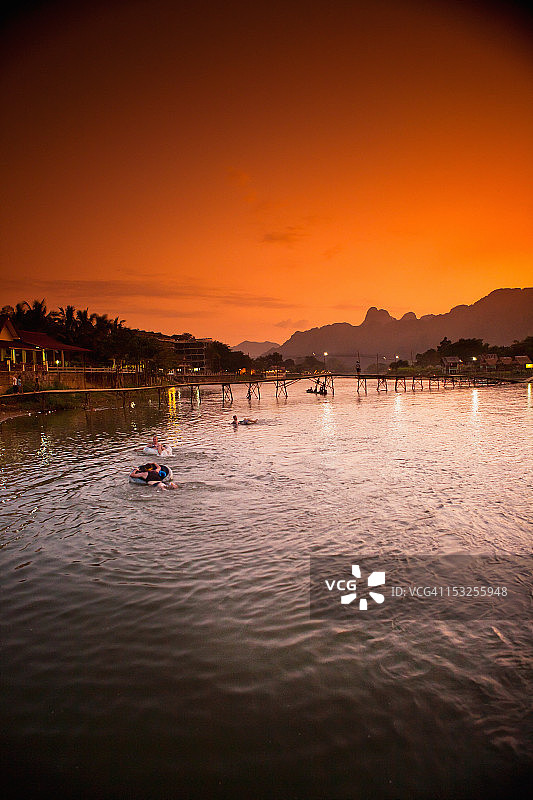 日落时分，人们在河上玩漂流圈图片素材