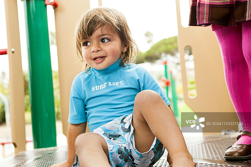 混血男孩在操场设施上玩耍图片素材