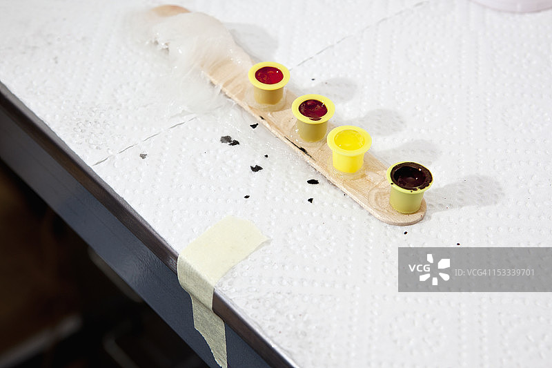 一排四个墨杯架，放在涂有凡士林的压舌板上图片素材