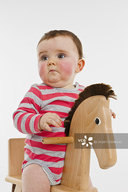 一个坐在摇摆木马上的女婴图片素材