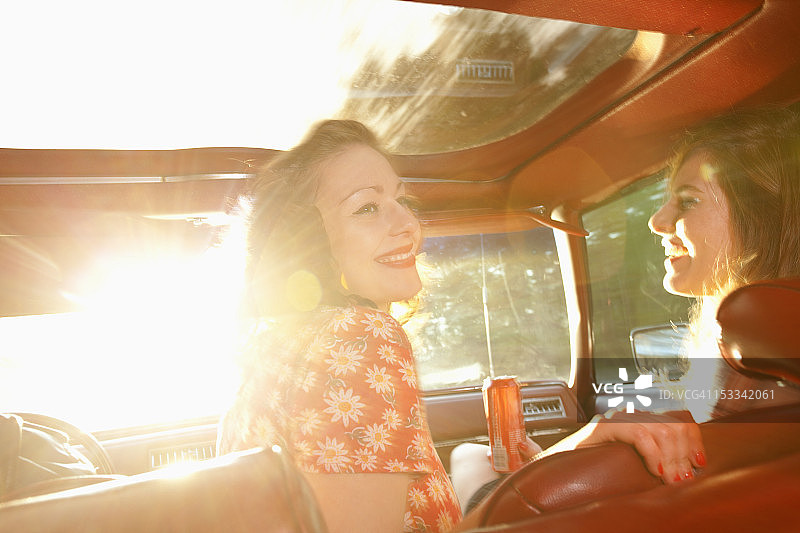 两名摇滚女郎在老爷车前座玩耍图片素材