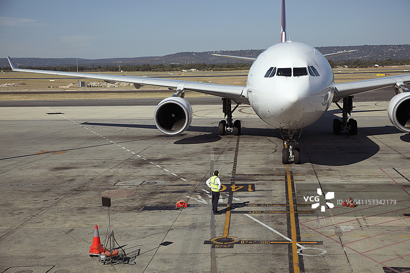 跑道上的地勤人员和喷气式飞机图片素材