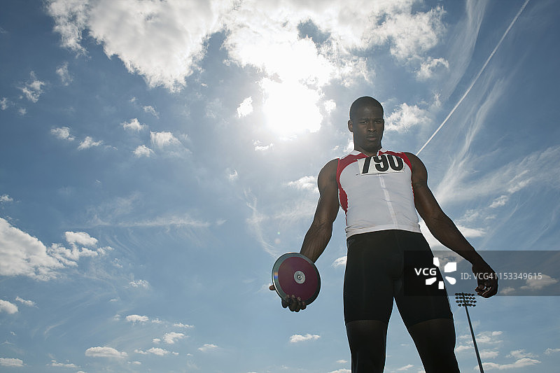 男运动员手持铁饼，低角度视角图片素材