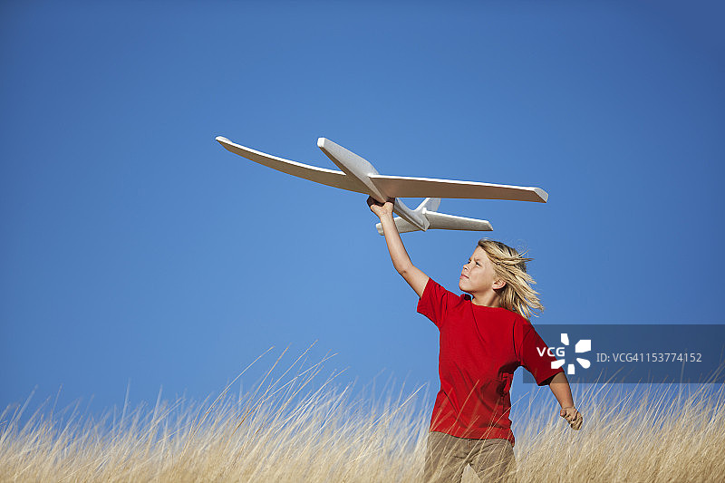 拿着玩具滑翔机的男孩图片素材