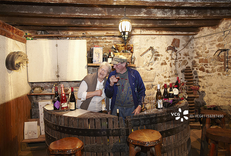 年长的夫妇在酒窖里品尝葡萄酒图片素材