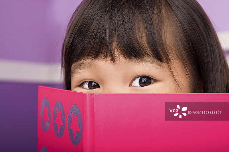 在卧室里阅读的可爱亚洲女孩图片素材