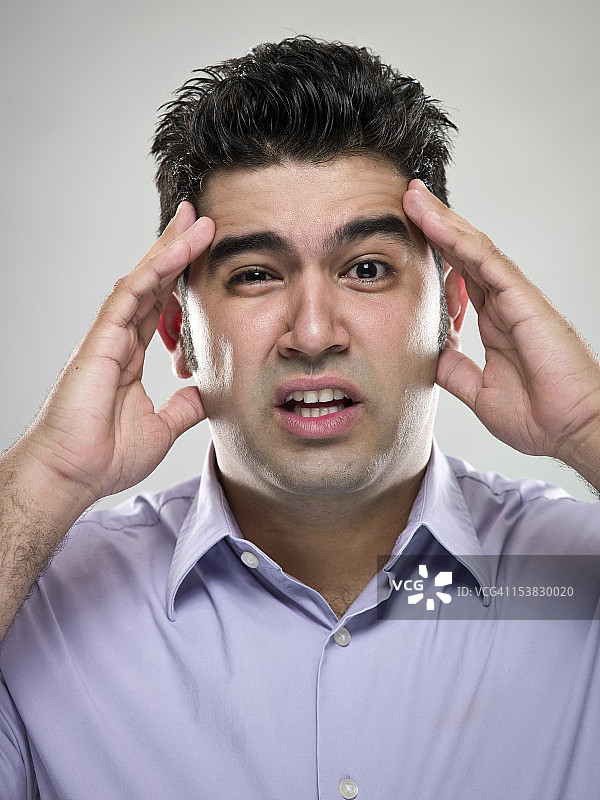 男人双手抱头，可能感到困惑或绝望图片素材