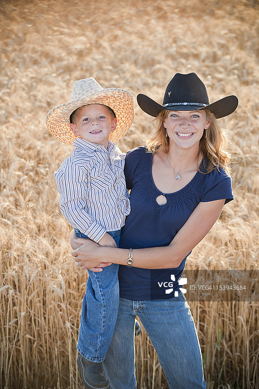 麦田里的冬小麦农民和她的儿子图片素材