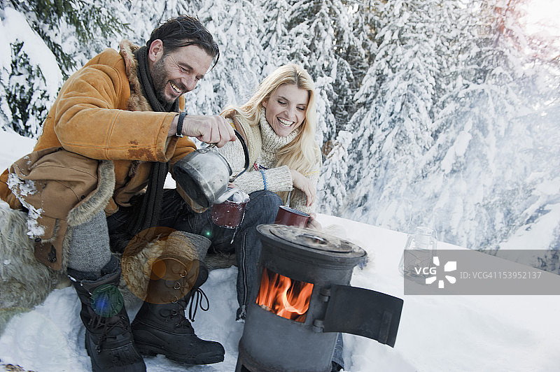 奥地利萨尔茨堡县，坐在野营炉子旁喝茶的夫妇图片素材