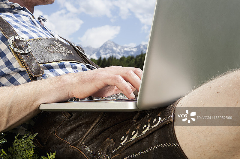 德国巴伐利亚州中年男子使用笔记本电脑图片素材
