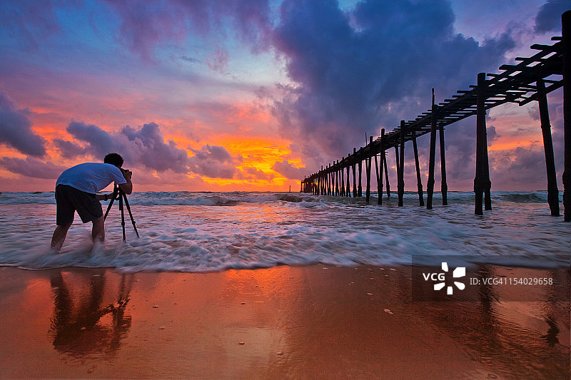摄影师在海滩拍摄日落图片素材